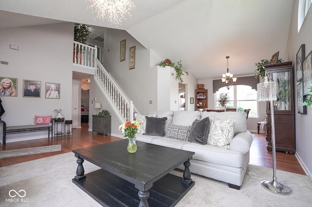 4342 Sequoia Ct, Greenwood, IN 46143 - living area featuring a chandelier, wood finished floors, high vaulted ceiling, and stairway