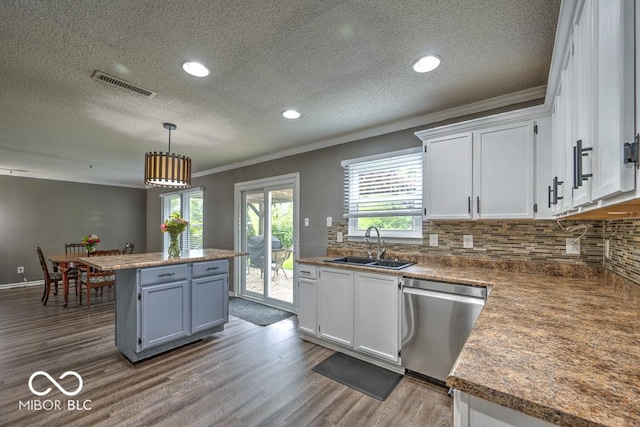 7657 Wheatgrass Ln, Noblesville, IN 46062 - kitchen featuring stainless steel dishwasher, ornamental molding, a sink, a textured ceiling, and white cabinetry