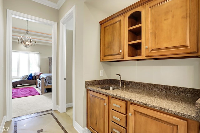 7635 Monte Carlo Way, Indianapolis, IN 46278 - kitchen with brown cabinets, inlaid floor details, a chandelier, ornamental molding, and dark stone counters