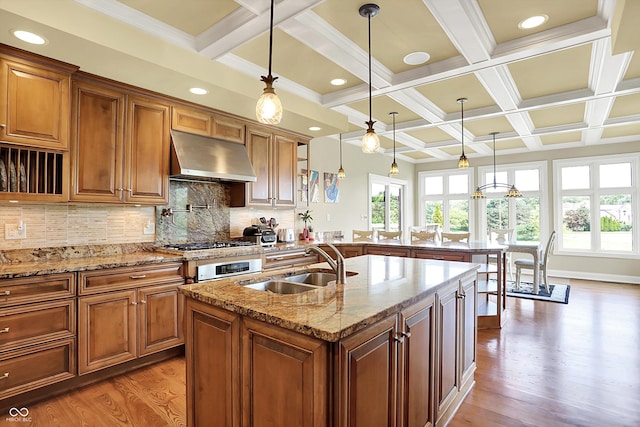 7635 Monte Carlo Way, Indianapolis, IN 46278 - kitchen with exhaust hood, light wood-style floors, healthy amount of natural light, coffered ceiling, and brown cabinets