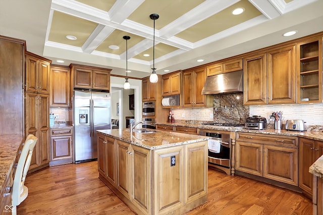 7635 Monte Carlo Way, Indianapolis, IN 46278 - kitchen with stainless steel appliances, under cabinet range hood, coffered ceiling, brown cabinets, and a center island with sink