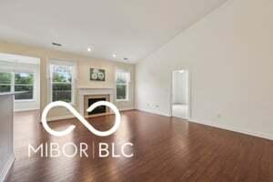 19146 Carol Cove Cir, Noblesville, IN 46062 - living room with wood finished floors, a fireplace, vaulted ceiling, and baseboards