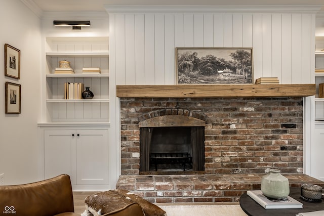 7105 Sylvan Ridge Rd, Indianapolis, IN 46240 - living room featuring built in shelves, crown molding, and a brick fireplace