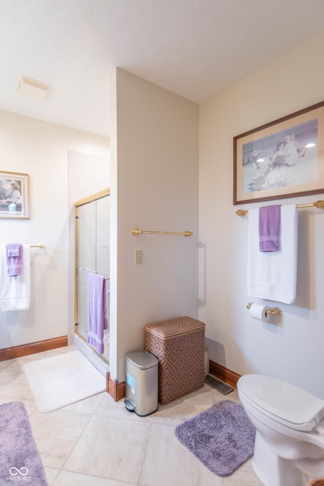 505 Jones Pl, Martinsville, IN 46151 - full bath featuring a stall shower, baseboards, toilet, a textured ceiling, and tile patterned floors