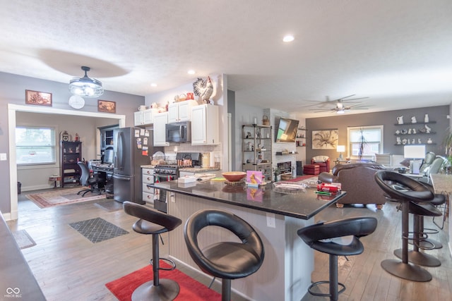 505 Jones Pl, Martinsville, IN 46151 - kitchen featuring stainless steel appliances, a breakfast bar, hardwood / wood-style floors, ceiling fan, and white cabinets