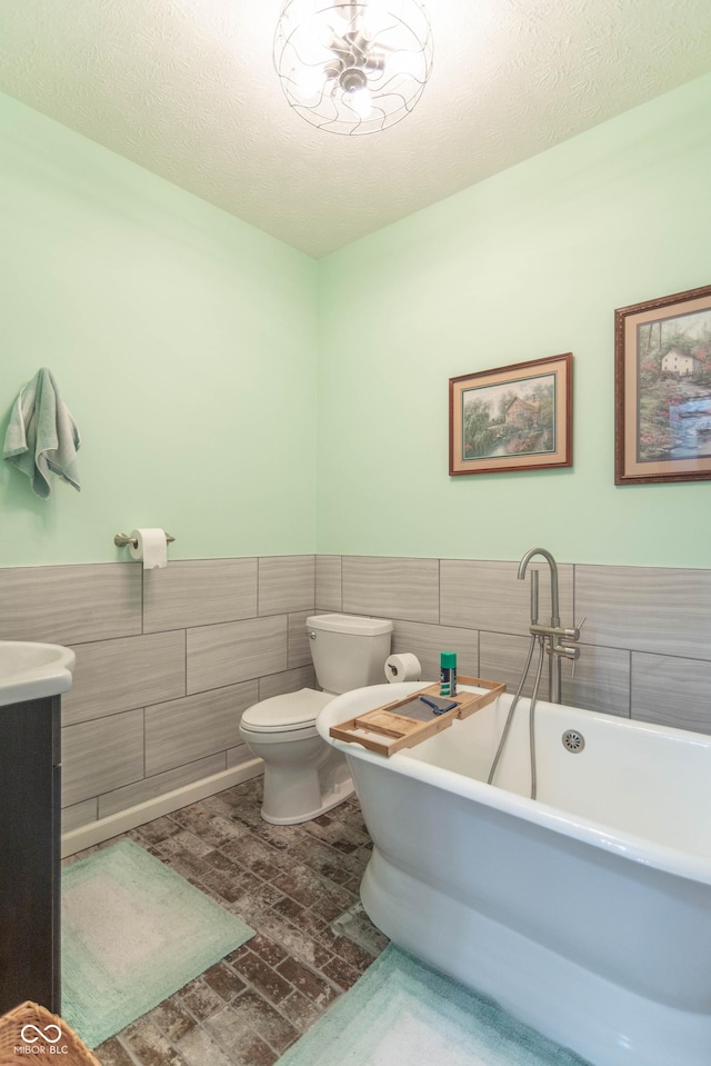 505 Jones Pl, Martinsville, IN 46151 - full bathroom with tile walls, a freestanding tub, toilet, a wainscoted wall, and vanity