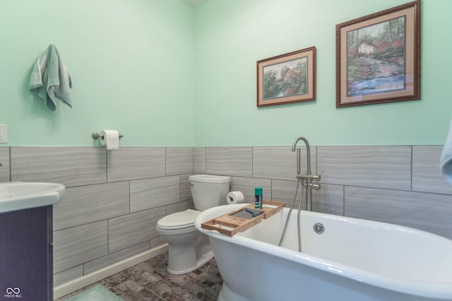 505 Jones Pl, Martinsville, IN 46151 - full bathroom featuring tile walls, a freestanding tub, toilet, vanity, and a wainscoted wall