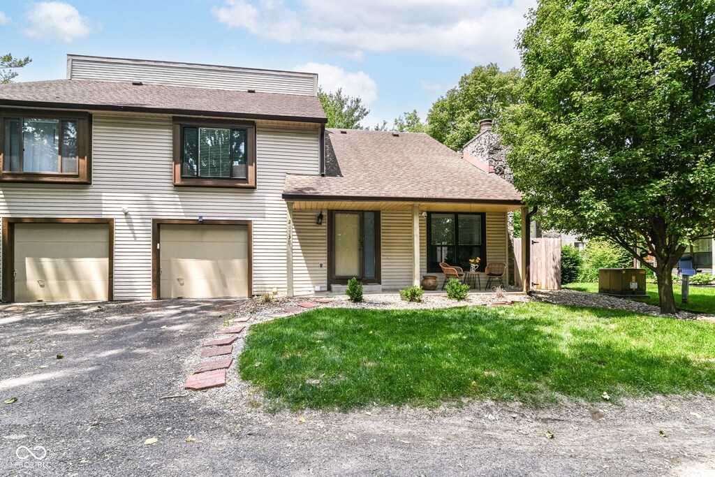 2433 Hideaway S Dr, Indianapolis, IN 46268 - view of front of property with a garage, roof with shingles, a front yard, asphalt driveway, and a chimney