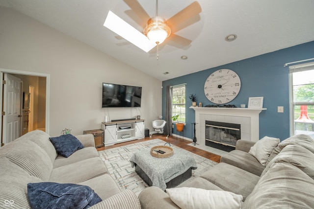 441 E Pine Ridge Dr, Westfield, IN 46074 - living room featuring vaulted ceiling, wood finished floors, a tiled fireplace, healthy amount of natural light, and a ceiling fan