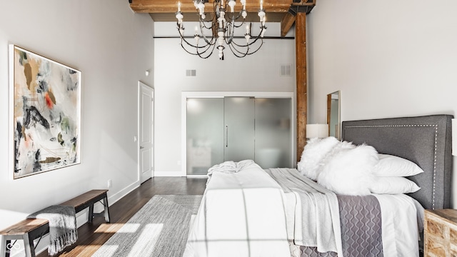 630 N College Ave Unit 409, Indianapolis, IN 46204 - bedroom featuring a high ceiling, wood finished floors, a chandelier, a closet, and baseboards