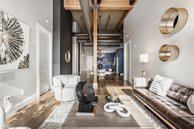 630 N College Ave Unit 409, Indianapolis, IN 46204 - living area featuring beam ceiling, a high ceiling, wood finished floors, and baseboards
