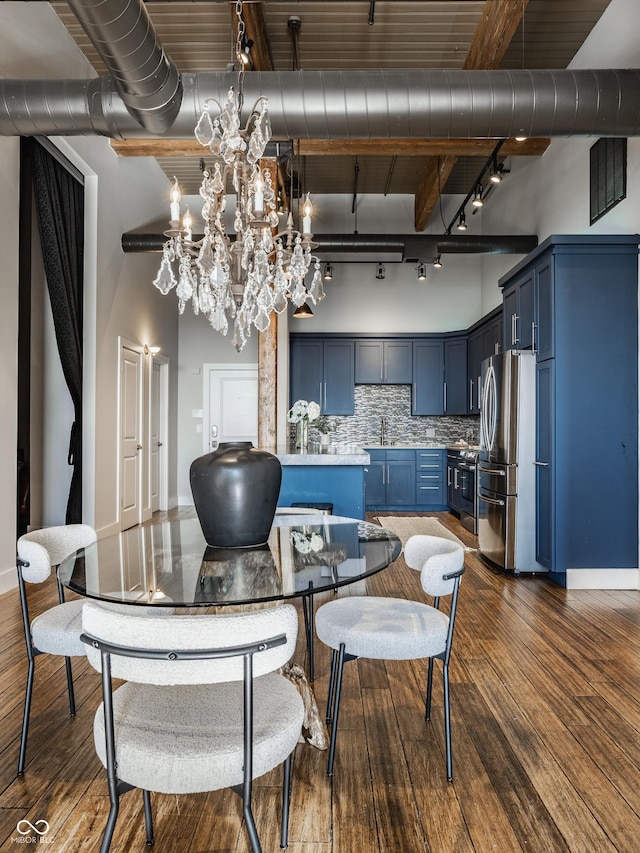 630 N College Ave Unit 409, Indianapolis, IN 46204 - dining room featuring track lighting, dark wood finished floors, a chandelier, baseboards, and beam ceiling