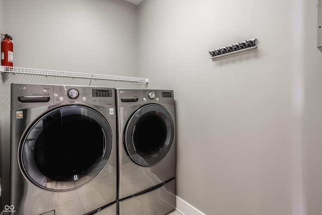 630 N College Ave Unit 409, Indianapolis, IN 46204 - laundry area with washer and clothes dryer, baseboards, and tile patterned flooring