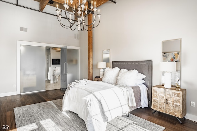 630 N College Ave Unit 409, Indianapolis, IN 46204 - bedroom with a towering ceiling, a chandelier, wood finished floors, baseboards, and beam ceiling