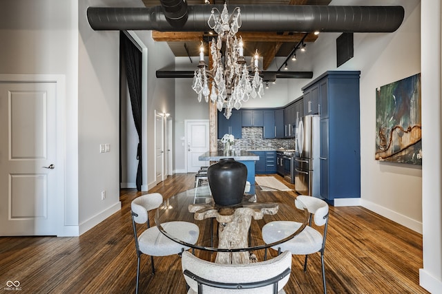 630 N College Ave Unit 409, Indianapolis, IN 46204 - dining space with a chandelier, a towering ceiling, baseboards, track lighting, and dark wood-type flooring