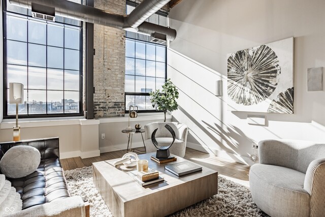 630 N College Ave Unit 409, Indianapolis, IN 46204 - living area featuring plenty of natural light, wood finished floors, baseboards, and a towering ceiling