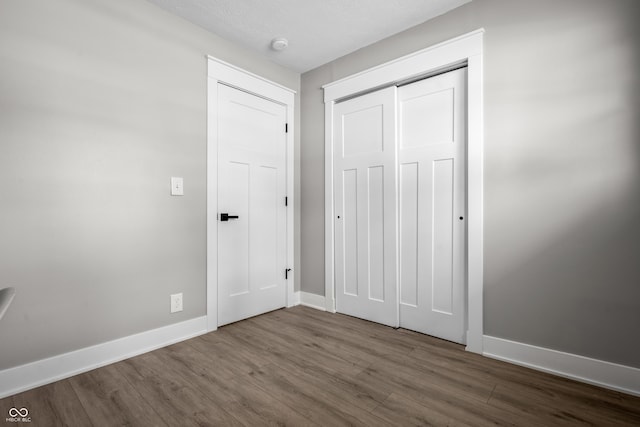 2537 N Boehning St, Indianapolis, IN 46219 - unfurnished bedroom featuring wood finished floors, baseboards, and a closet