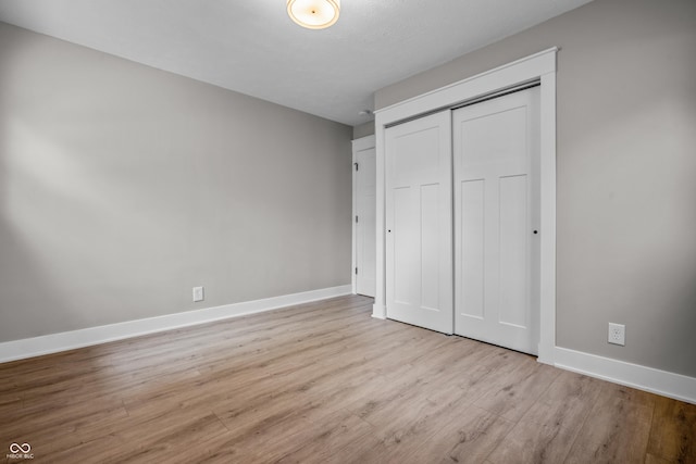 2537 N Boehning St, Indianapolis, IN 46219 - unfurnished bedroom featuring baseboards, wood finished floors, and a closet