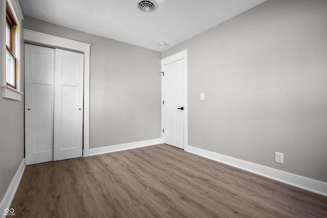 2537 N Boehning St, Indianapolis, IN 46219 - unfurnished bedroom with wood finished floors, baseboards, and a closet