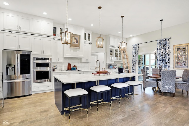 1135 Maclaren Ct, Franklin, IN 46131 - kitchen featuring appliances with stainless steel finishes, a chandelier, light wood finished floors, backsplash, and recessed lighting