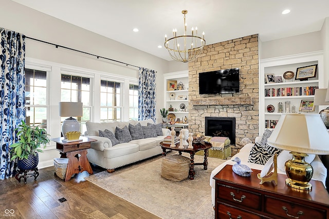 1135 Maclaren Ct, Franklin, IN 46131 - living room featuring wood finished floors, a chandelier, a stone fireplace, recessed lighting, and built in shelves