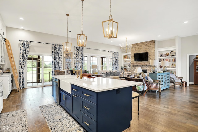 1135 Maclaren Ct, Franklin, IN 46131 - kitchen featuring a chandelier, blue cabinetry, dark wood-type flooring, stainless steel dishwasher, and a breakfast bar