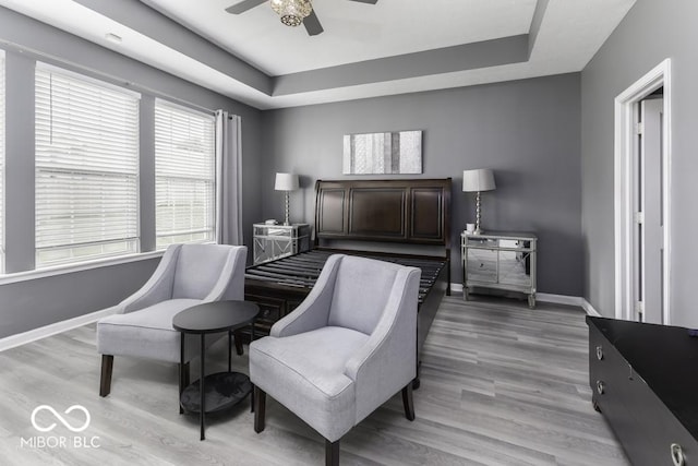 2502 Colinbrook Pkwy, Greenwood, IN 46143 - bedroom featuring a raised ceiling, baseboards, light wood-style flooring, and a ceiling fan