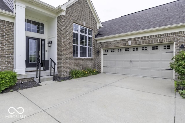 2502 Colinbrook Pkwy, Greenwood, IN 46143 - doorway to property featuring brick siding, driveway, a garage, and a shingled roof