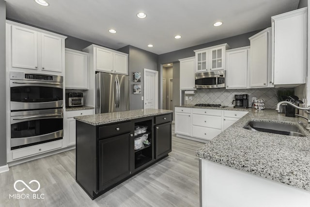 2502 Colinbrook Pkwy, Greenwood, IN 46143 - kitchen with stainless steel appliances, a sink, white cabinetry, light stone countertops, and tasteful backsplash