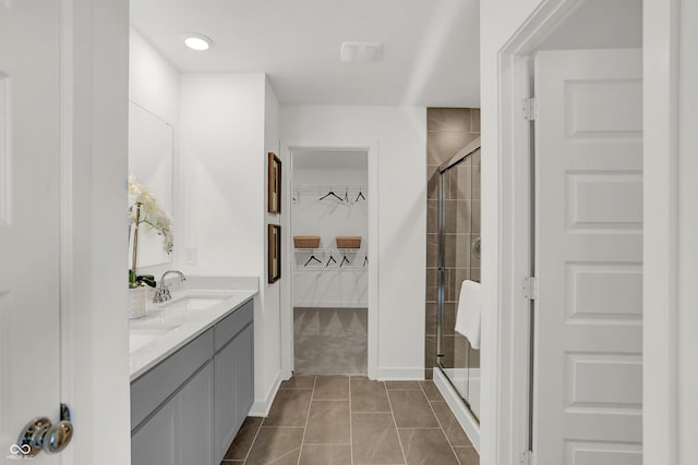942 Shadow Dr, Danville, IN 46122 - bathroom featuring a walk in closet, a stall shower, double vanity, and tile patterned flooring