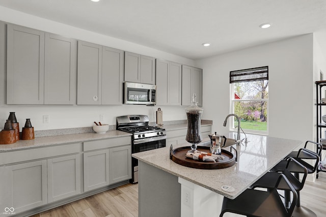 942 Shadow Dr, Danville, IN 46122 - kitchen featuring appliances with stainless steel finishes, gray cabinets, light wood finished floors, recessed lighting, and light stone countertops