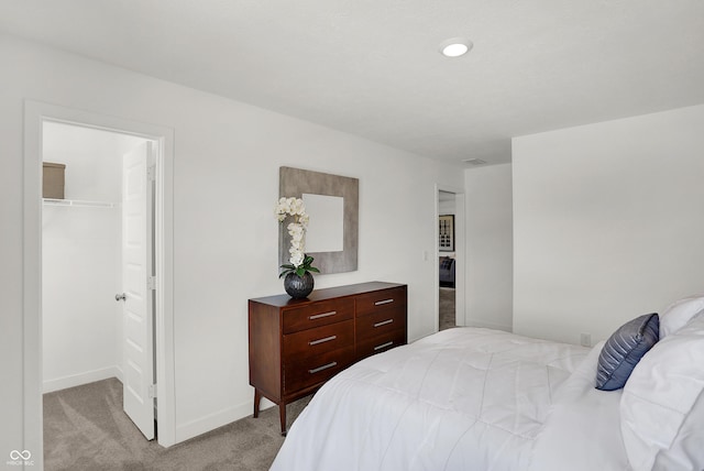 942 Shadow Dr, Danville, IN 46122 - bedroom featuring a walk in closet, light carpet, a closet, and baseboards