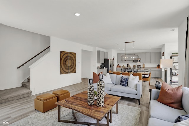 942 Shadow Dr, Danville, IN 46122 - living room with light wood-style flooring, stairs, a chandelier, and recessed lighting