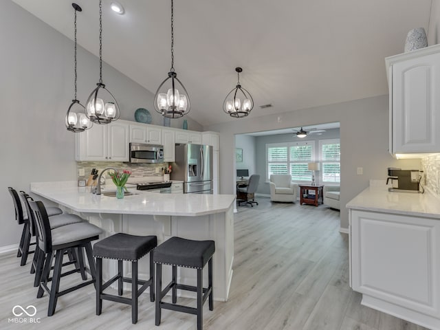 5351 Abbington Ave, Plainfield, IN 46168 - kitchen featuring appliances with stainless steel finishes, a peninsula, backsplash, a chandelier, and white cabinetry