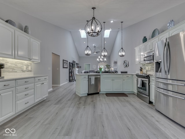 5351 Abbington Ave, Plainfield, IN 46168 - kitchen with stainless steel appliances, a peninsula, a chandelier, backsplash, and white cabinetry