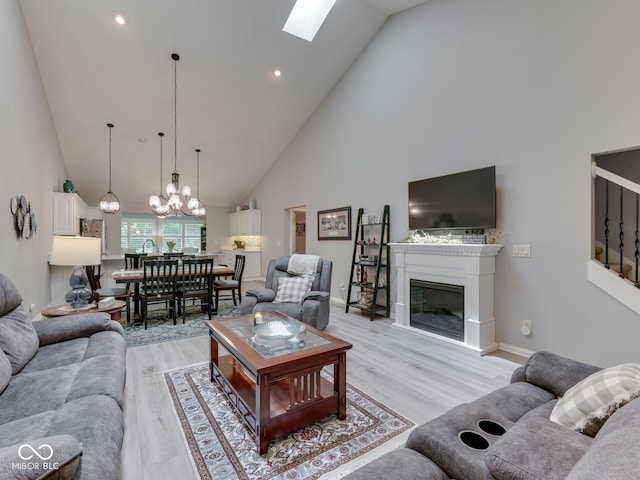5351 Abbington Ave, Plainfield, IN 46168 - living area with high vaulted ceiling, light wood-type flooring, a glass covered fireplace, a chandelier, and stairway