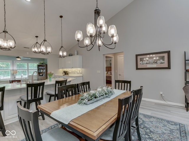 5351 Abbington Ave, Plainfield, IN 46168 - dining space featuring a chandelier, light wood-type flooring, high vaulted ceiling, and ceiling fan
