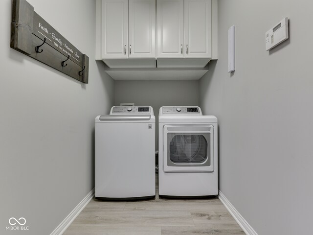 5351 Abbington Ave, Plainfield, IN 46168 - laundry room featuring washer and dryer, cabinet space, and light wood-type flooring