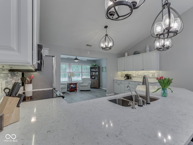 5351 Abbington Ave, Plainfield, IN 46168 - kitchen featuring a chandelier, backsplash, a ceiling fan, white cabinets, and light stone counters