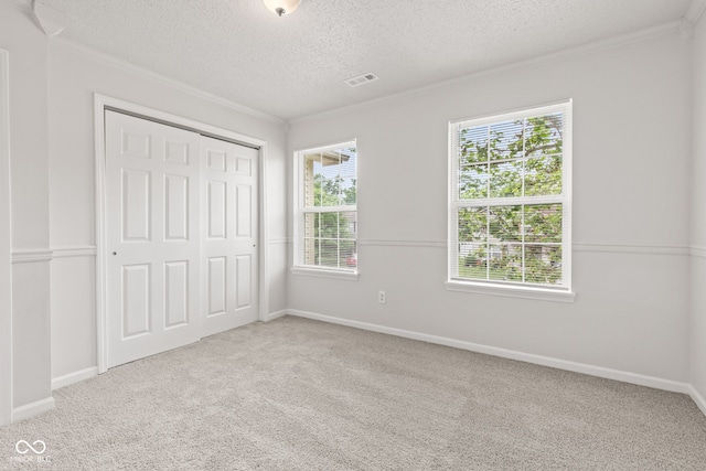 1903 Windy Hill Ln, Indianapolis, IN 46239 - unfurnished bedroom featuring ornamental molding, a textured ceiling, multiple windows, carpet floors, and a closet