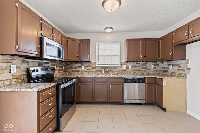 1903 Windy Hill Ln, Indianapolis, IN 46239 - kitchen with appliances with stainless steel finishes, backsplash, a textured ceiling, and light tile patterned floors
