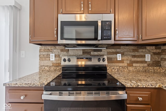 1903 Windy Hill Ln, Indianapolis, IN 46239 - kitchen with appliances with stainless steel finishes, backsplash, and light stone countertops