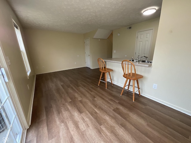 2853 S Walnut Street Pike, Bloomington, IN 47401 - kitchen with dark wood-style flooring, a breakfast bar, a textured ceiling, and light countertops