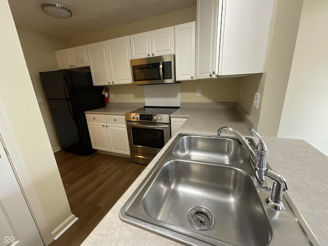 2853 S Walnut Street Pike, Bloomington, IN 47401 - kitchen with appliances with stainless steel finishes, white cabinetry, dark wood finished floors, and light countertops