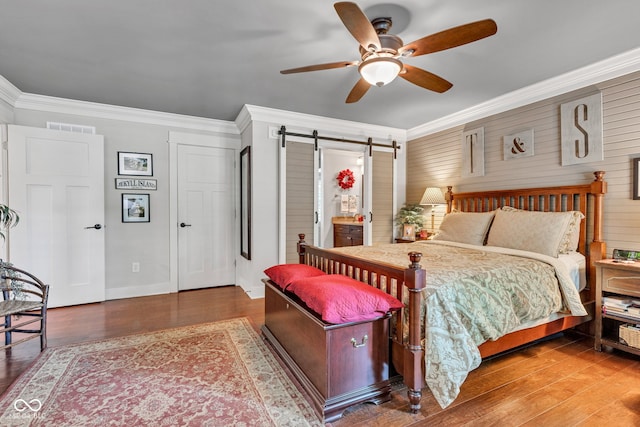 900 W Busby St, Lebanon, IN 46052 - bedroom featuring a barn door, crown molding, wood finished floors, and a ceiling fan