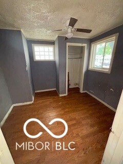 1724-1726 N Somerset Ave, Indianapolis, IN 46222 - unfurnished bedroom featuring baseboards, a textured ceiling, multiple windows, a closet, and wood finished floors