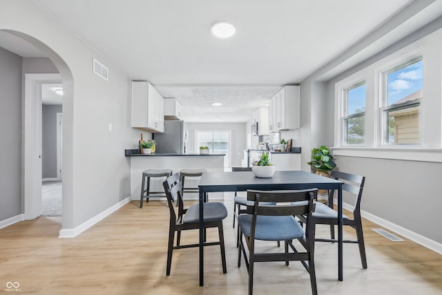 3906 Fletcher Ave, Indianapolis, IN 46203 - dining area with baseboards, light wood-style floors, arched walkways, and recessed lighting