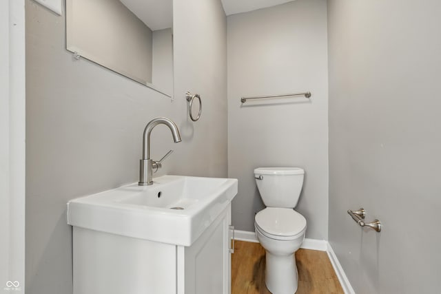 3906 Fletcher Ave, Indianapolis, IN 46203 - half bathroom featuring wood finished floors, toilet, and baseboards