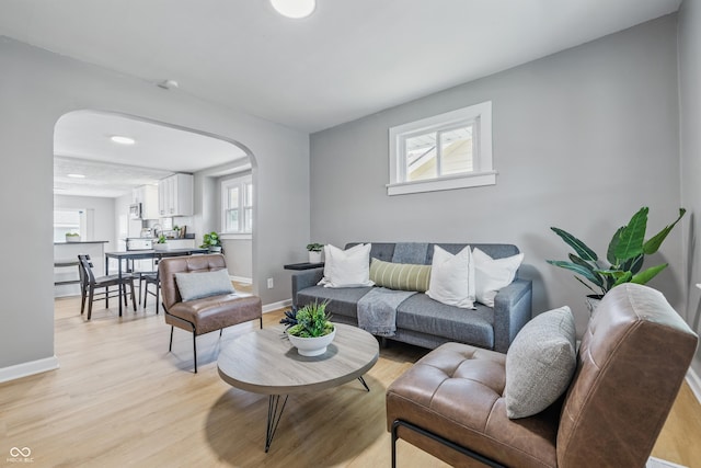 3906 Fletcher Ave, Indianapolis, IN 46203 - living area with arched walkways, light wood-style flooring, and baseboards