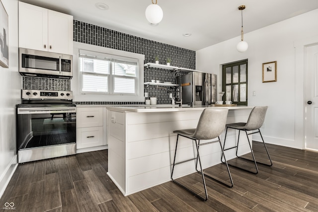 805 N Temple Ave, Indianapolis, IN 46201 - kitchen featuring appliances with stainless steel finishes, a breakfast bar, dark wood finished floors, and white cabinetry